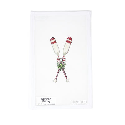 Hand-painted 18 mesh needlepoint canvas by Danielle Murray featuring a pair of crossed oars adorned with a holiday wreath. Rich in nautical detail with a festive twist, ideal for finishing as a Christmas ornament or part of a coastal holiday display
