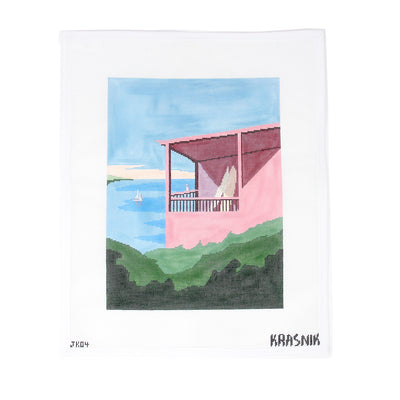 Needlepoint canvas by Krasnik featuring a pink seaside house with a covered balcony overlooking the water, with a sailboat in the distance and lush greenery in the foreground. Soft pastel tones in pink, blue, and green evoke a tranquil coastal scene. Perfect for finishing as a framed piece, pillow, or decorative panel. Printed on 18-count mesh. Mesh size: 18-count, square.