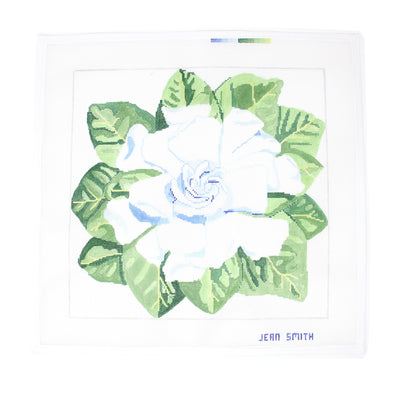 "Hand-painted needlepoint canvas by Jean Smith featuring a large, elegant gardenia flower with soft white petals and green foliage, 14" square on 13 mesh—perfect for finishing as a sophisticated pillow, framed floral artwork, or a decorative tray.