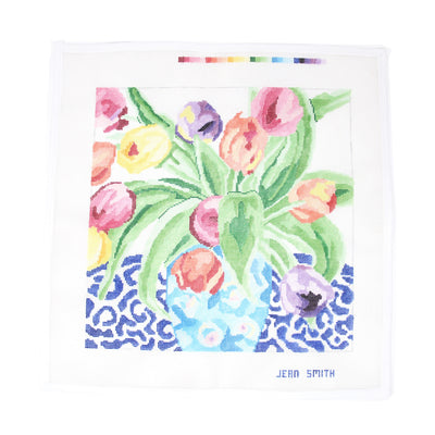 Hand-painted needlepoint canvas of a Parisian-style bouquet featuring multicolored tulips in a light blue vase, set against a blue and white marbled background—perfect for finishing as an elegant pillow, framed floral artwork, or a decorative spring tray.