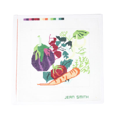 Hand-painted needlepoint canvas featuring a colorful assortment of vegetables including eggplant, radish, tomato, and carrots—ideal for finishing as a kitchen tray, framed wall art, or a vibrant veggie-themed pillow