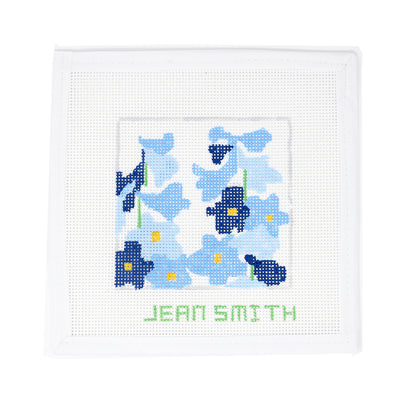 Hand-painted needlepoint canvas featuring a stylized Delphinium flower in shades of blue on white mesh, designed by Jean Smith—perfect for finishing as a garden-themed ornament, framed decor, or a fun coaster