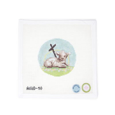 Circular needlepoint ornament canvas by Annie MacKenzie featuring a “Lamb of God” design—depicting a gentle lamb lying in the grass beside a cross, symbolizing Easter. Hand-painted on 13 mesh, this beginner-friendly design is perfect for finishing as a meaningful ornament, framed devotional piece, or a special Easter keepsake.