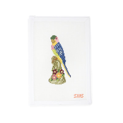 Hand-painted needlepoint canvas featuring a colorful bird perched on a floral pedestal, designed by Stitching with Stacey. This vibrant design on 13 mesh canvas is perfect for spring or tropical-themed stitching. Ideal for finishing as a door hanger, small pillow insert, or framed as whimsical wall art.