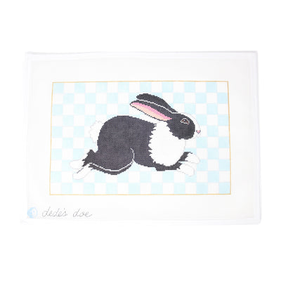 Black and White Bunny Needlepoint canvas featuring a detailed bunny on a blue and white checkered background. Perfect for creating a framed piece, pillow, or seasonal decor. Printed on 13-count mesh. Mesh size: 13-count, square.